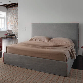 Distinguished Horm Tahiti bed with medium-grey textile upholstery, red trim and mocha lacquered beechwood feet