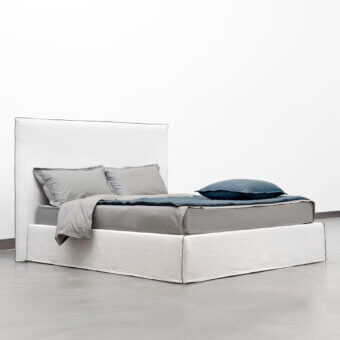 Superior Horm Tahiti bed with white textile upholstery, dark trim and mocha lacquered beechwood feet