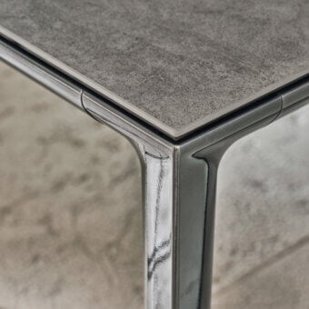 Elegant Bontempi Duke Square table with textured gray tabletop and sleek reflective metal frame legs