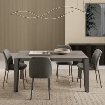 Bontempi dining table with matte gray rectangular top, dark gray base, six sage green upholstered chairs, gray rug, beige ribbed wall panels.