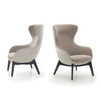 Pacini&Cappellini Sally lounge chairs, beige fabric upholstery, wingback design, angled dark legs, studio lighting.