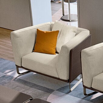 Exceptional Turri Milano lounge chair with comfortable fabric cushions and woven leather panels built with curved brushed nickel metal legs
