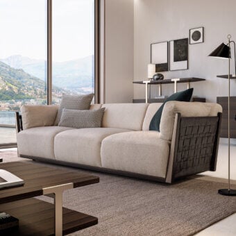 Exceptional Turri Net sofa with Eucalyptus wood frame, woven leather detailing and light beige textile upholstery complemented by checkered pillows