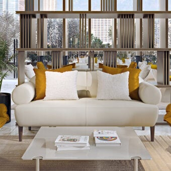 Lavish Turri Silhouette sofa with soft seating and tubular armrests in refined cream-colored fabric with slender dark wooden legs