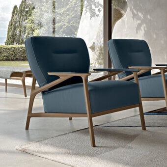 Elegant Turri Vine lounge chair with branched natural wood and cool-toned blue textile upholstery exhibiting a light finish
