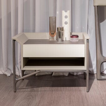 Elegant Turri Vine nightstand in light cream leather with dark gray wood, presenting an asymmetrical silhouette and metal framework