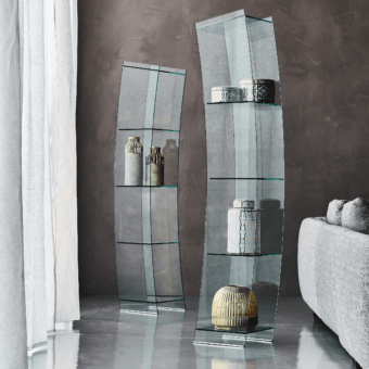Cattelan Italia curved glass showcases with dark gray metal bases display ceramic vases and a gold accent against a gray wall.