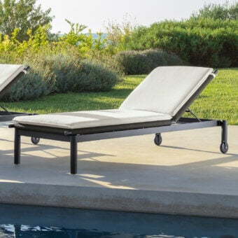 Sophisticated Talenti Dolcevita Alu lounger with dark metal frame and woven seat, offering an off-white padded cushion and adjustable backrest