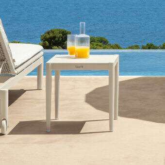 Distinguished Talenti Dolcevita Alu side table with square top and slender cylindrical legs in a neutral tone and matte finish