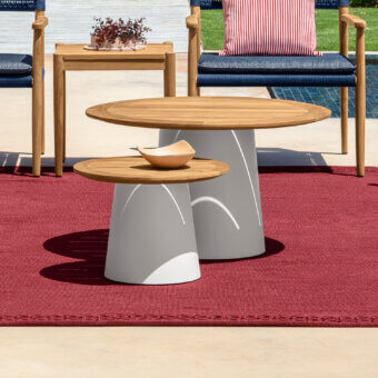 Harmonious Talenti Dolcevita Wood coffee table with a round teak wood top and light-colored aluminum base exhibiting curved indentation detail