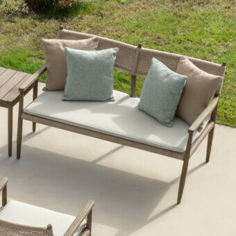 Distinguished Talenti Dolcevita Wood love seat sofa with light brown wood and woven rope detailing, complemented by light gray cushions and pillows