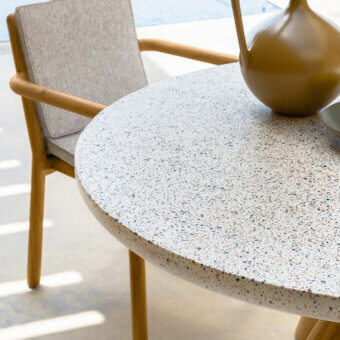 Sophisticated Talenti Prichi table with speckled pastel grit top and warm-toned teak wood legs crafted in Italy