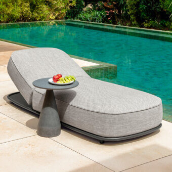 Sophisticated Talenti Swipe lounger with light gray woven textile and dark metal frame, complemented by a speckled gray side table