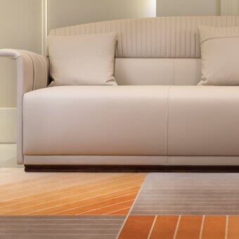 Superior Turri Madison sofa with light cream textile or leather upholstery and stylish vertical embroidery