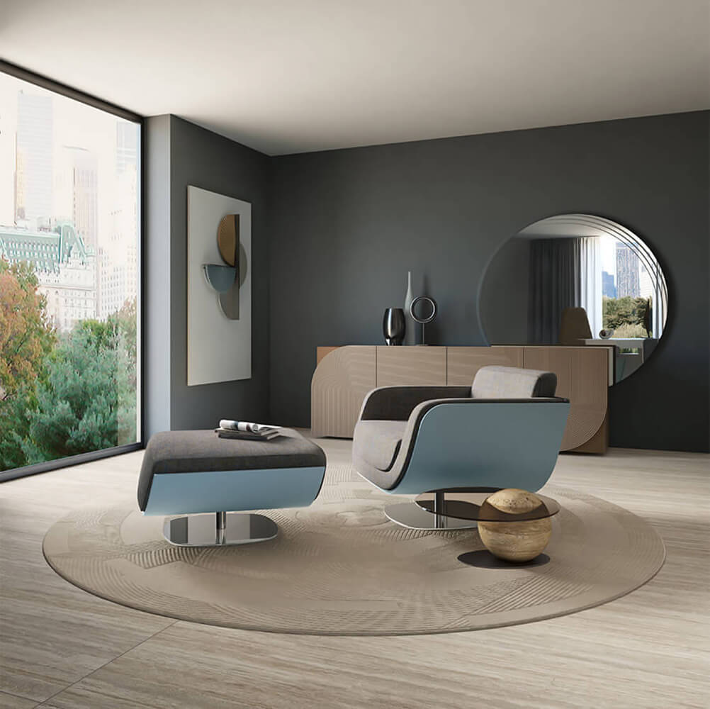Blue Bizzotto lounge chair with ottoman, curved back, metal swivel base, in modern gray room with wood floors and cityscape view.