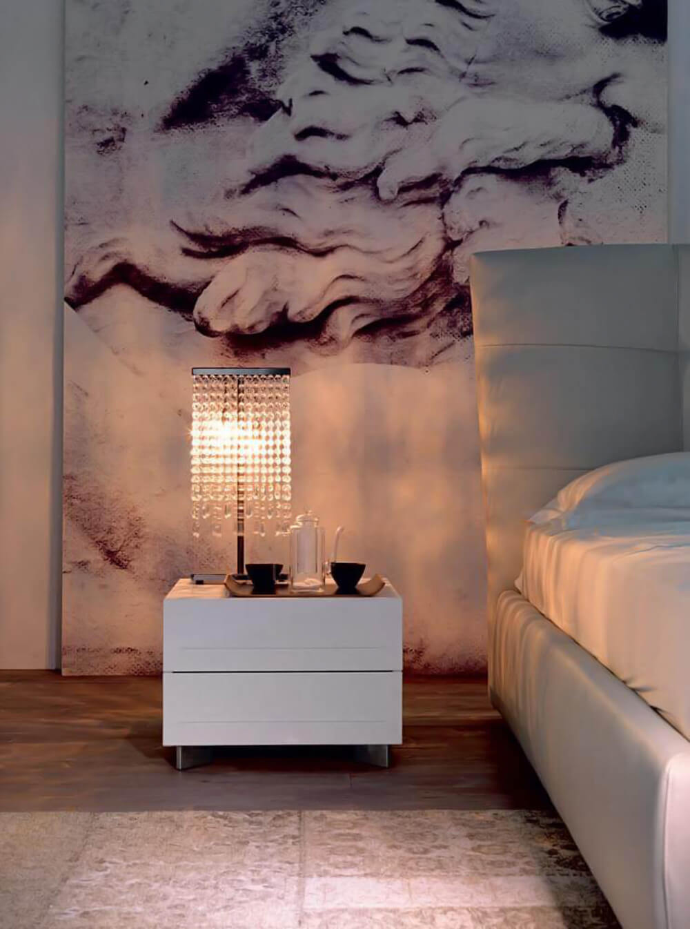 Cattelan Italia Dyno nightstand, white lacquer, rectangular form, with lamp, dish, and black & white sculpture backdrop.