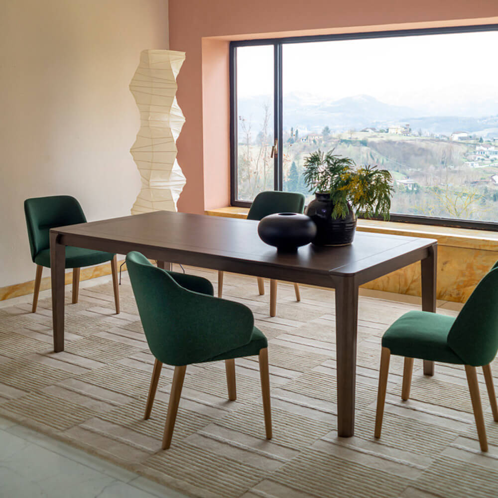 Potocco blossom table, gray-brown rectangular top, with four green velvet dining chairs and a white textured lamp in a modern dining room.