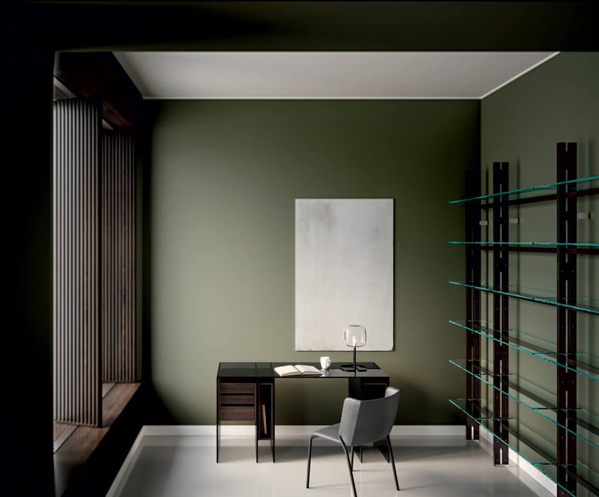 Tonelli bookcase with metal frame and glass shelves, dark wood desk, gray chair, white artwork, minimalist room interior.