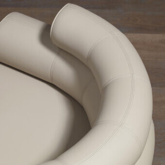 Lounge chair, off-white synthetic leather, curved back and cylindrical base with detailed stitching, studio product shot.