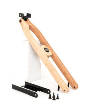 Wooden bicycle stand with black bird logo, light wood grain, angled arms, central pivot knob, mounting brackets, and “cherry” plaque.
