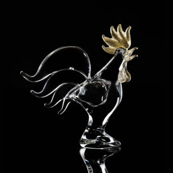Glass rooster sculpture by Duccio Di Segna, transparent body with gold comb and wattle, on clear pedestal, black background.