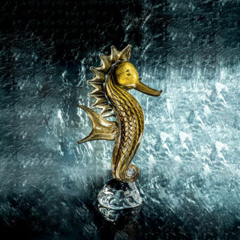 Glass seahorse sculpture by Duccio Di Segna on clear spherical base, featuring textured body, curved tail, and marbled glass details.