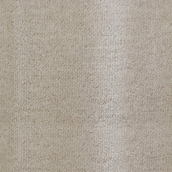 Beige textile surface with dense pile and directional grain, exhibiting subtle shading from light to dark, matte finish, studio shot.