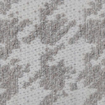 Textured fabric sample with repeating gray floral motifs on cream, showing raised embroidery and a visible grid weave; “1126 stucco wr” visible.