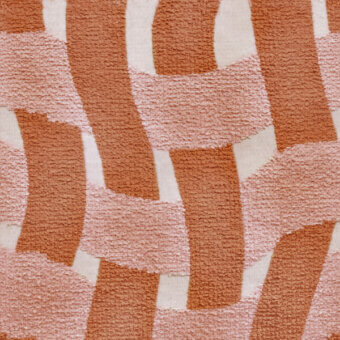 Abstract rug with terracotta and blush pink blocks on cream, featuring a dense looped pile texture and irregular, vertical shapes.