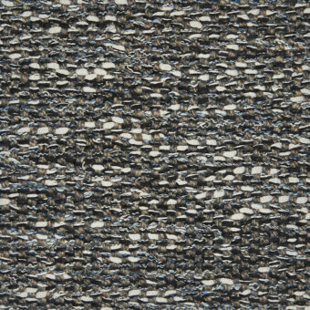 Charcoal gray tweed textile with flecks of light gray, off-white, and blue, displaying a dense, looped, irregular woven pattern and nubby texture.