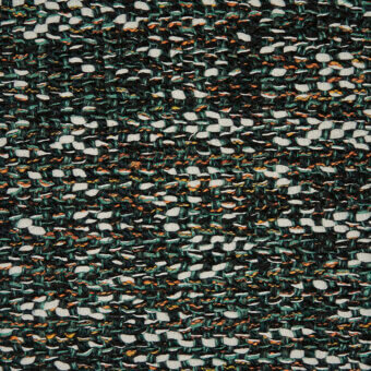Textile with repeating organic shapes in dark green, white, orange, and teal; nubby knit texture with a raised, uneven surface.