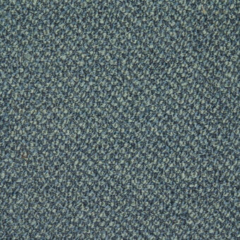 Muted teal fabric sample displaying a granular, heathered pattern with beige flecks; tightly woven texture with a nubby surface.