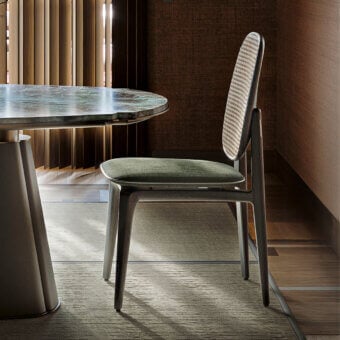 Distinguished Giorgetti Plume chair crafted with solid ash wood, muted green textile upholstery, and a natural Viena straw backrest with satin finish