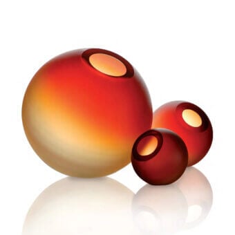 Murano glass vases, yellow to red gradient, spherical shape with circular openings, reflective surface, white background.
