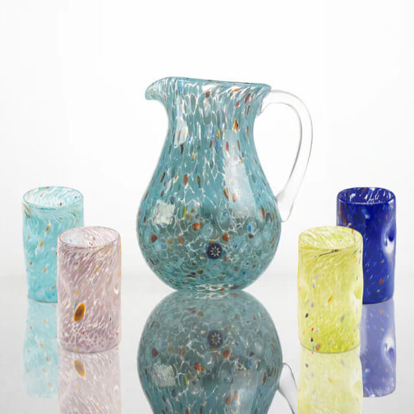 Cassoni glassware set, turquoise pitcher & colorful tumblers, crackled textures, clear glass, looped handle, white reflective surface.