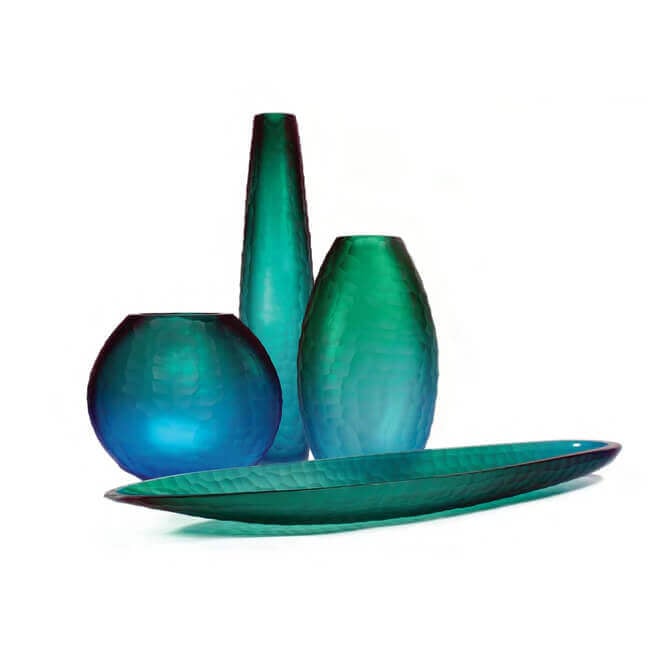 Murano glass vases and dish, teal, blue, green hues, rippled texture, varying cylindrical, globe, oval, bulbous forms, white background.