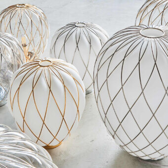 Glass lamps, FontanaArte style, clustered on gray; spherical shapes feature white opaque glass, metallic grid patterns, and clear ribbed glass.
