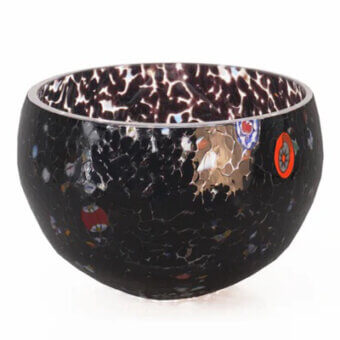Glass bowl, black with white spotted pattern, featuring red, blue, gold inclusions and swirling interior lines, studio shot.