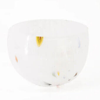 White glass bowl with speckled pattern, rounded shape, and translucent surface featuring yellow, orange, blue, and pink inclusions.