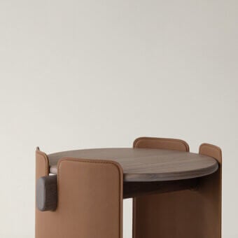 Distinguished Cierre1972 Maori side table with circular wood tabletop and tan leather wrapped base in satin finish
