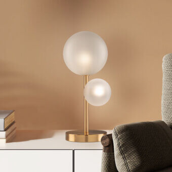 Bubbles table lamp, frosted glass shades, brushed brass stem, circular base, warm light, neutral beige background, interior setting.
