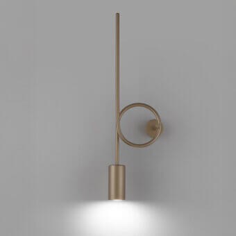 Dopamine wall lamp, brushed brass, vertical rod with circular loop; minimalist design casts focused light on gray wall.