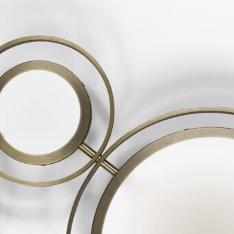 Brass wall lamp, circular design, three concentric rings with geometric framework and opaque white shade, brushed metal finish.