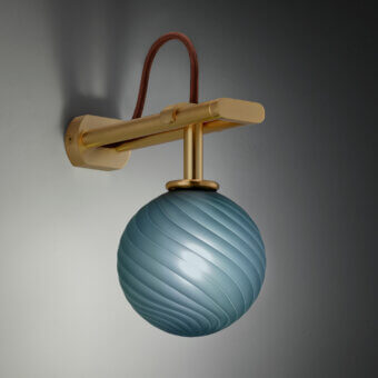 Wall lamp, brass and glass, horizontal arm with light blue spherical shade featuring ridged texture, brown cord, gradient gray backdrop.
