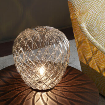 Distinguished FontanaArte Pinecone table lamp crafted with caged blown glass in a glossy, galvanic amber hue with faceted texture