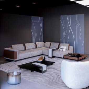 Distinguished Giorgetti Nereide sectional upholstered in gray with brown leather accents and a pewter-finished wood base