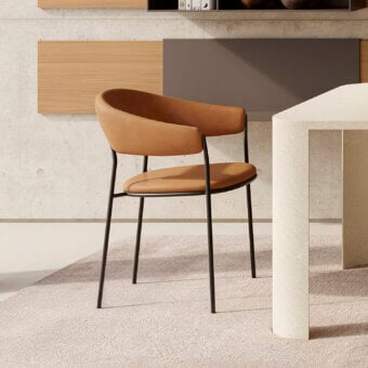 Distinguished MDF Italia Archie armchair with a seamlessly curved backrest and dark metal frame upholstered in medium brown textile with matte finish