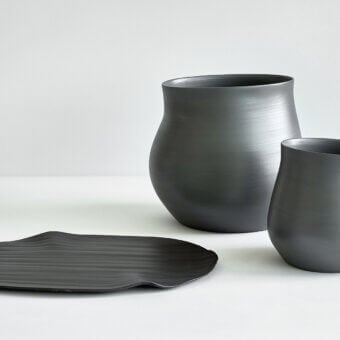 Superior Rina Menardi Agape vessel handcrafted in baked clay with a smooth matte dark gray finish