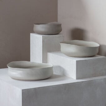 Distinguished Rina Menardi Cenote vessels crafted from baked clay with a subtly textured, minimalist form in a light grey tone