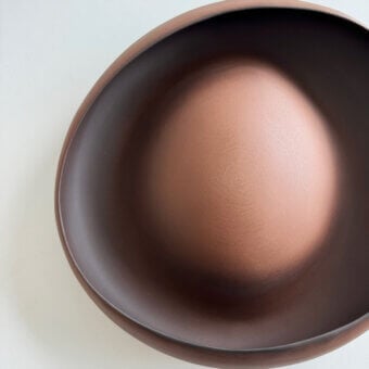 Distinguished Rina Menardi Ellissi centerpiece crafted in reddish-brown baked clay with a smooth matte finish and curved silhouette